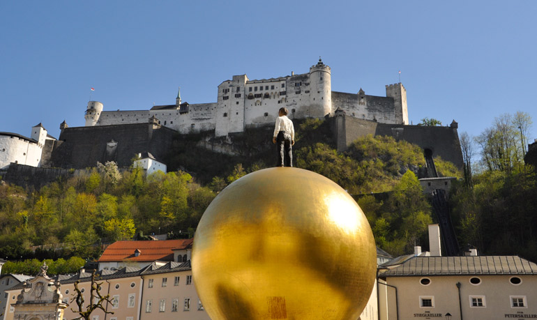 Die Festung Hohensalzburg prangt auf dem Festungsberg hoch über der Stadt, im Vordergrund die 'Balkenhol Mozartkugel' am Kapitelplatz!