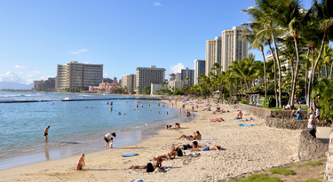 Waikiki ein Vorort von Honolulu ist eine perfekt geölte Urlaubsmaschine... die Hotelstadt türmt sich hoch über den Palmen am Strand. Direkt dahinter drängen sich coole Läden und Restaurants...